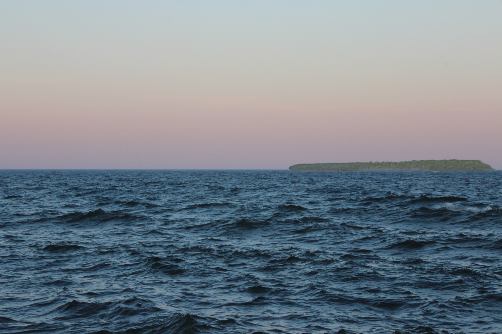 Porte des Morts at dusk, dark choppy water with a low island on the horizon